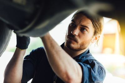 Close-up of mechanic working at garage