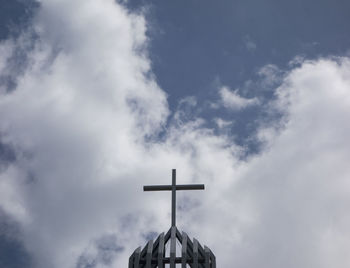 Low angle view of weather vane against sky