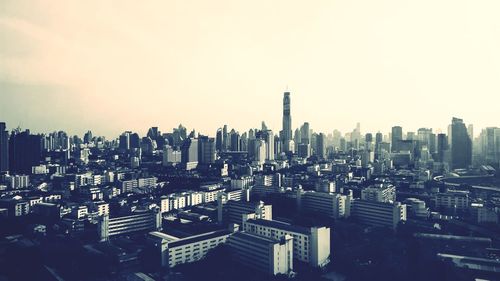 Aerial view of buildings in city against clear sky