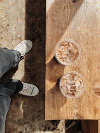 Low section of man standing on wooden table