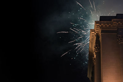 Low angle view of fireworks against sky at night
