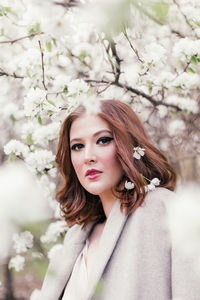 Beautiful girl in a dress walking in a blooming garden