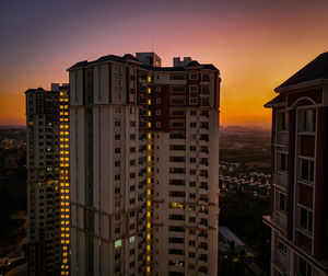 Buildings in city against sky during sunset