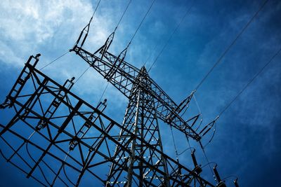 Low angle view of electricity pylon against sky