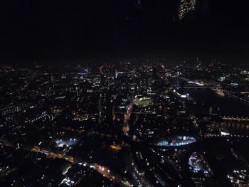 High angle view of illuminated buildings against sky at night