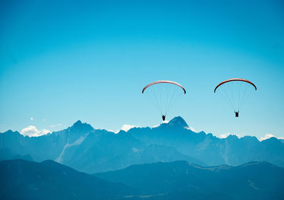Low angle view of person paragliding against mountain