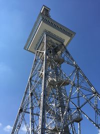 Low angle view of communications tower against blue sky