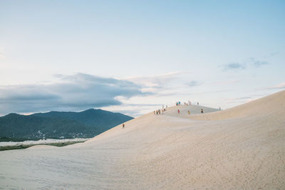 Scenic view of sand dune against sky