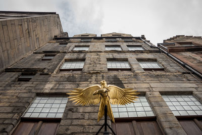 Low angle view of statue against historic building