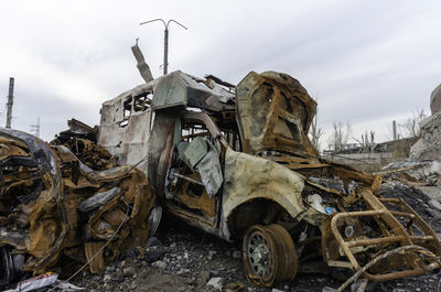 Abandoned vehicle on field against sky