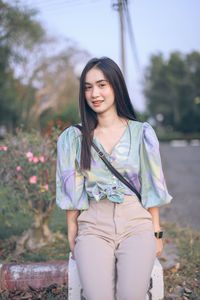 Portrait of beautiful young woman standing outdoors