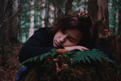 Young woman looking away in forest