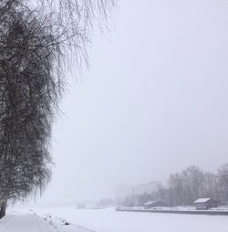 Snow covered field against clear sky