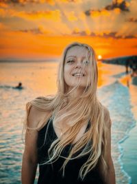 Portrait of young woman swimming in sea during sunset