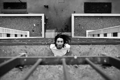 High angle view portrait of woman standing by railing