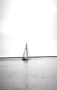 Sailboat in sea against sky