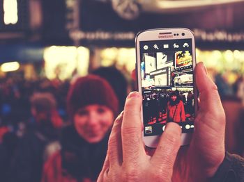 Close-up of cropped hand holding mobile phone