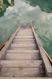 Surface level of wooden footbridge over pier against sky