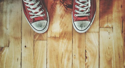 Low section of person standing on hardwood floor