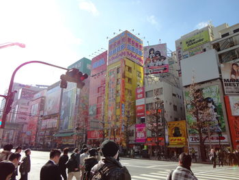 Crowd on road in city against sky