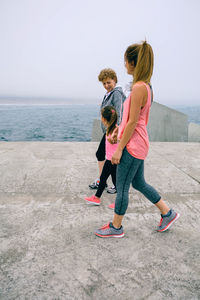 Girl with mother and grandmother walking on pier