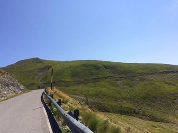 Country road against clear blue sky