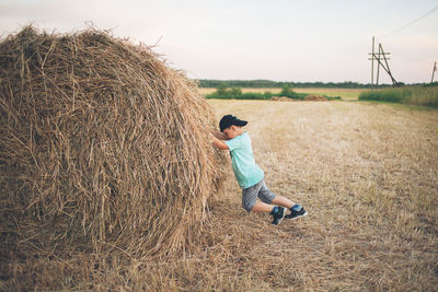 Rear view of man standing on hay