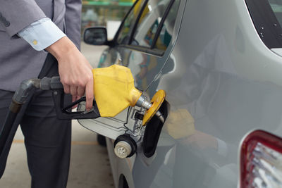 Midsection of man holding car