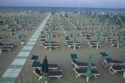 Chairs on beach against sky