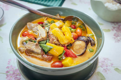 High angle view of thai roasted duck curry in bowl on dining table