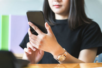 Midsection of woman using mobile phone
