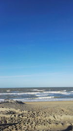 Scenic view of beach against blue sky