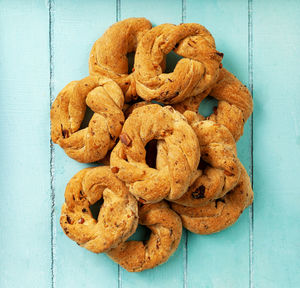 Italian taralli snacks with black pepper and almond on a mint wooden table.