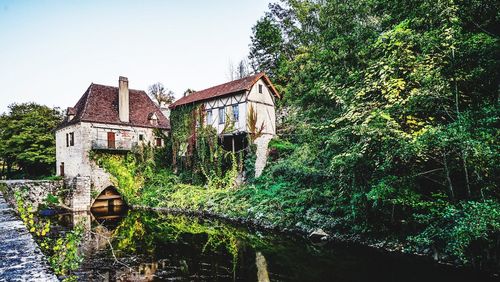 Old building by trees against clear sky