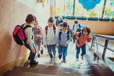 Rear view of people walking on staircase