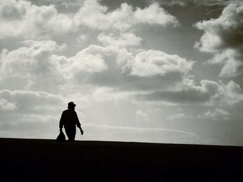 Silhouette of man against cloudy sky