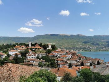 High angle view of townscape by sea against sky