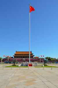 Red flag on building against clear blue sky