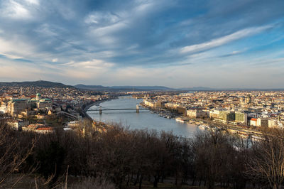 High angle view of river amidst buildings in city against sky