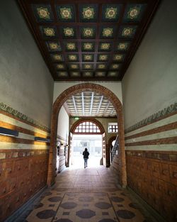 Rear view of woman walking in tunnel