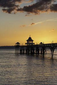 Pier over sea against sky during sunset