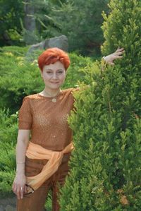 Portrait of woman standing by trees