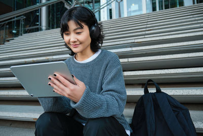 Portrait of young woman using digital tablet