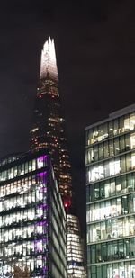 Low angle view of illuminated buildings against sky at night