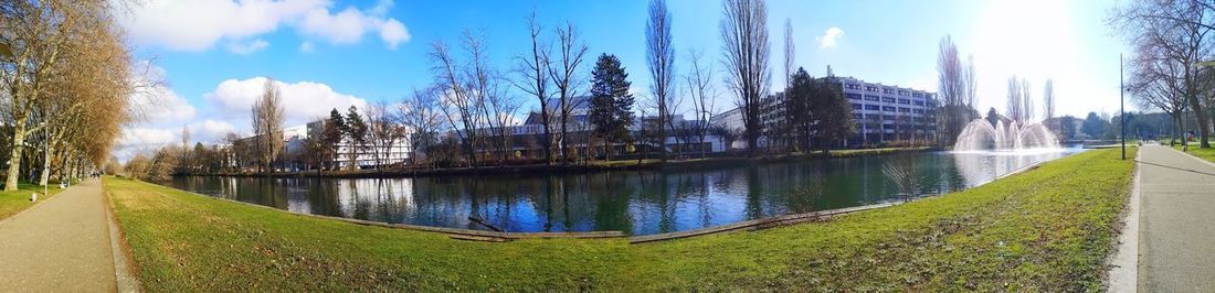 Panoramic shot of city by river against sky