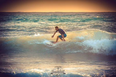 Woman jumping on beach against sky during sunset