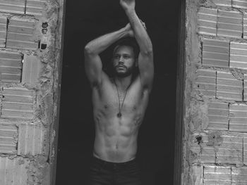 Portrait of young man standing against wall