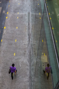 Reflection of person walking on pavement at siam square