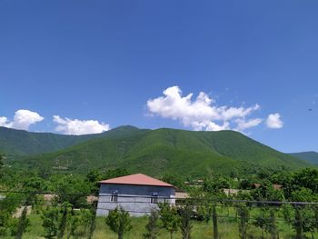Scenic view of house and mountain against sky