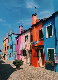 Houses by street against sky in city